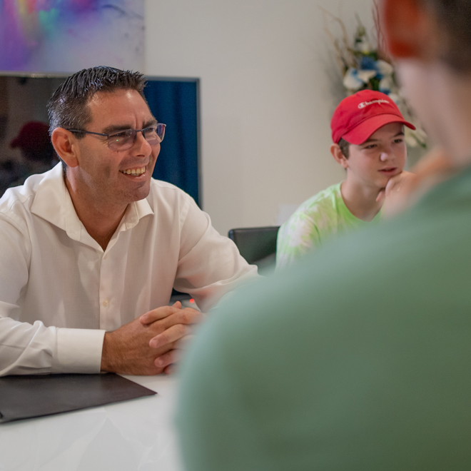 Man sitting at a table smiling and participating in a meeting