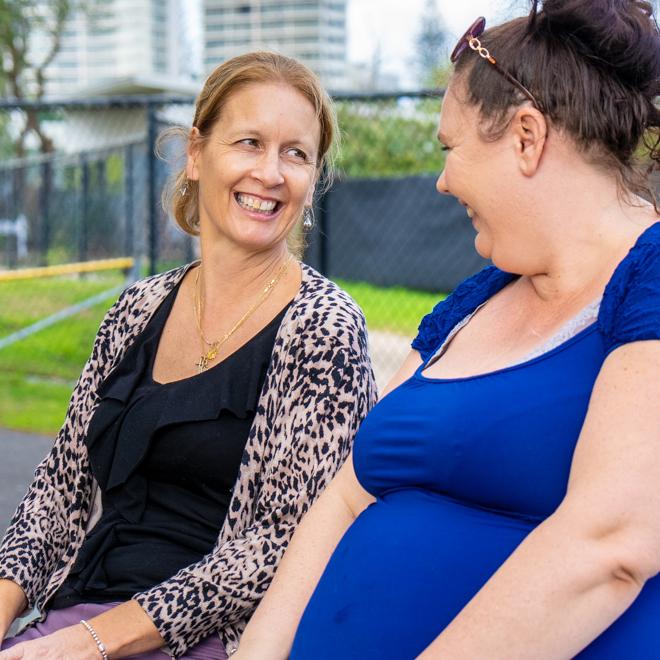 Support worker sitting and smiling with client